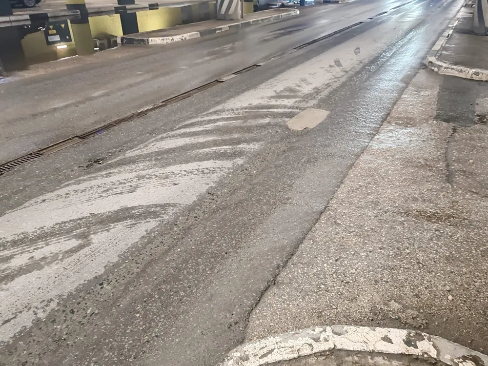Полосы износа покрытия у шлагбаума на выезде из паркинга
